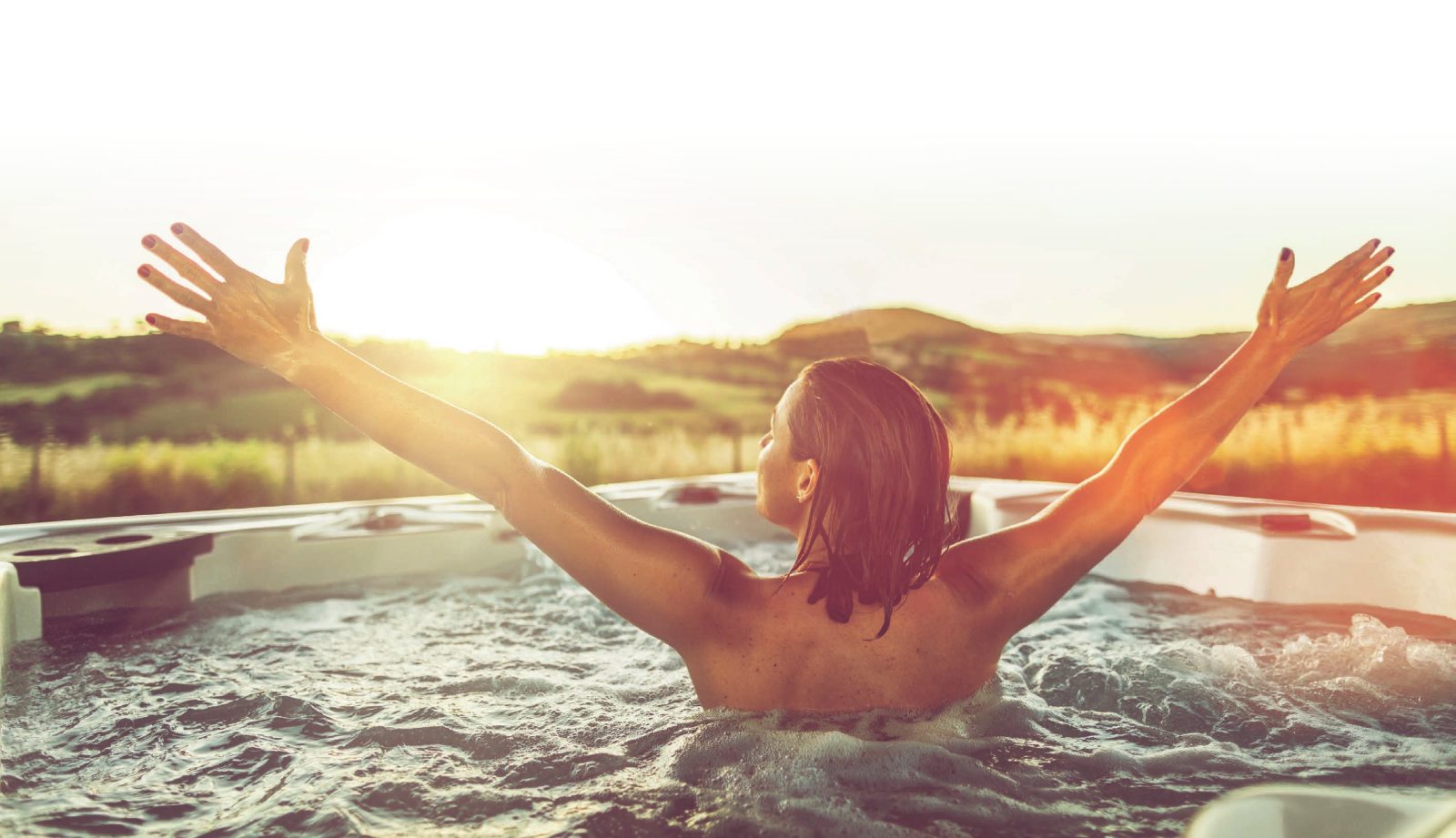 Frau in einem Whirlpool bei Sonnenuntergang